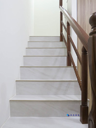 磨石子樓梯面材打除，貼灰色霧面拋光磚；紅色塑膠鐵扶手更換為櫸木扶手